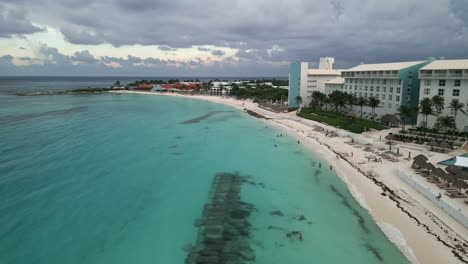 Beautiful-Cancun-Beach-with-Clear-Blue-Waters-Along-the-Coastal-Beachfront-with-Hotels-and-Resorts-Overlooking-the-Ocean