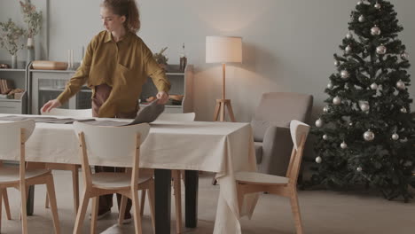 woman preparing dining table for christmas