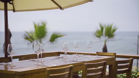 great shot of restaurant table with wine glasses set in seascape background, peru