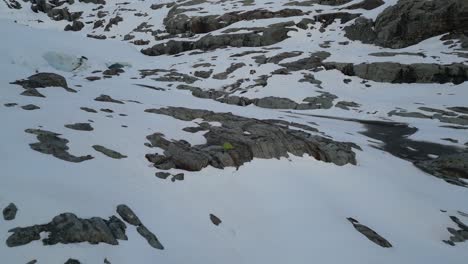 a man sitting on a rock in front of his tent near brewster glacier