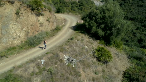 Aerial-tracking-shot-of-female-runner-exercising-in-the-mountains