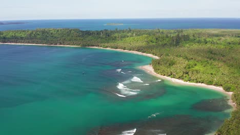 toma de revelación aérea de olas rompientes en la laguna indonesia de color turquesa tropical