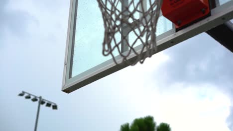 dripping wet basketball backboard after heavy rainfall on city playground