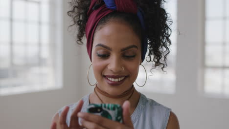 slow-motion-portrait-of-young-hispanic-woman-in-new-apartment-smiling-enjoying-texting-browsing-using-smartphone-social-media-technology