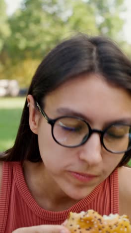 woman eating a burger in a park