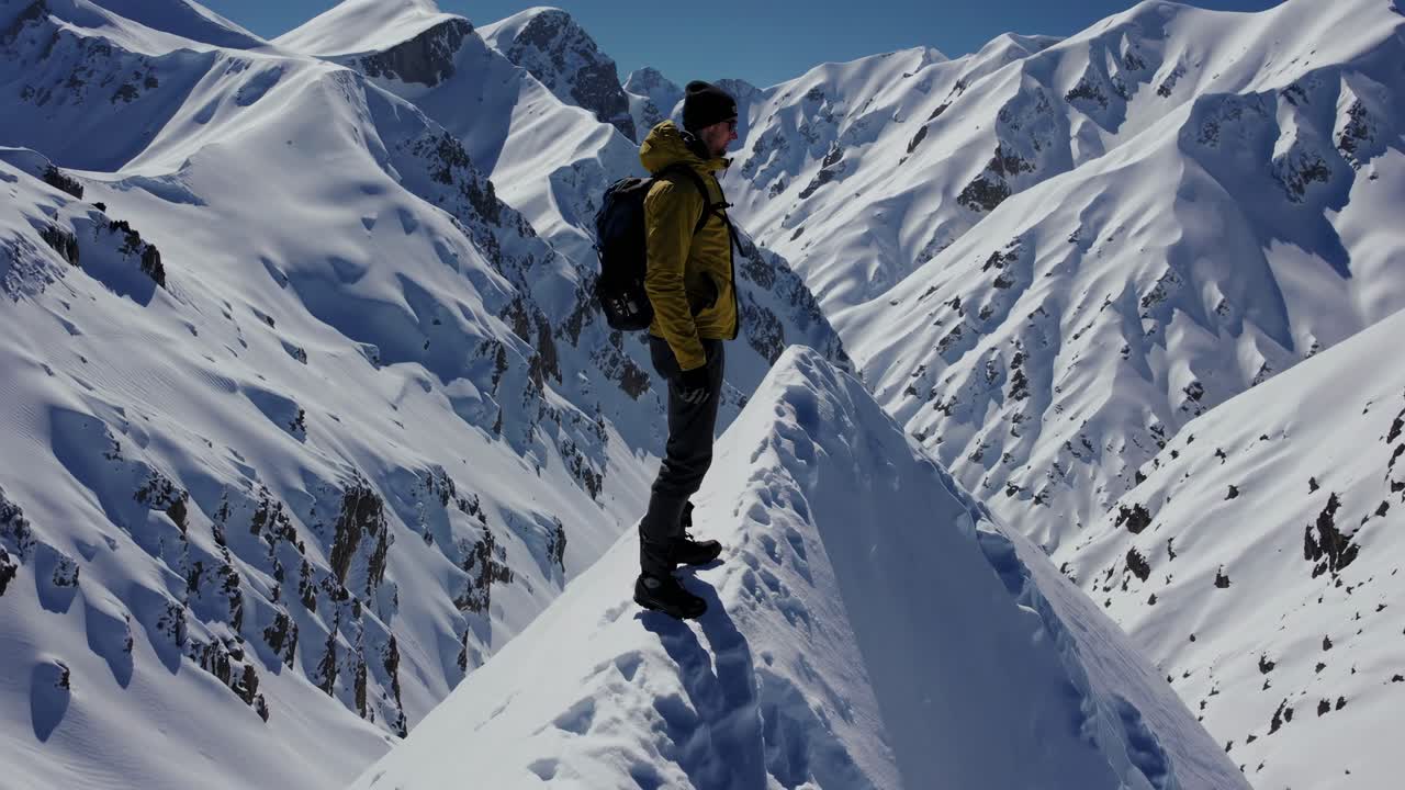 Hiker on Snow-Capped Mountain Peak