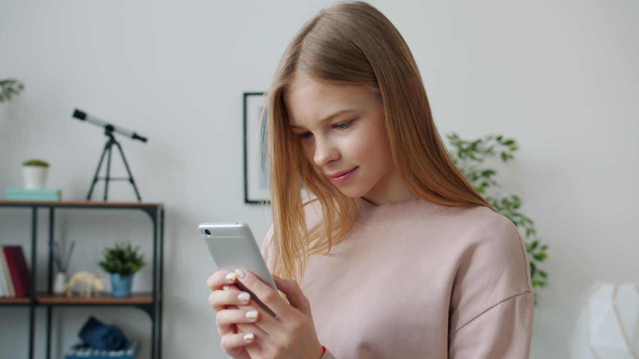 Ragazza adolescente che usa lo smartphone a casa