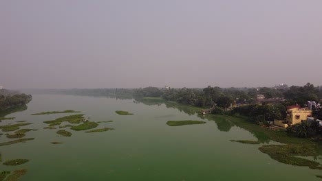 Drone-shot-flying-over-small-pond-in-Indian-village