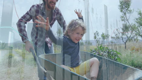 Man pushing child in wheelbarrow along rural path, showing floating finance charts and candlesticks