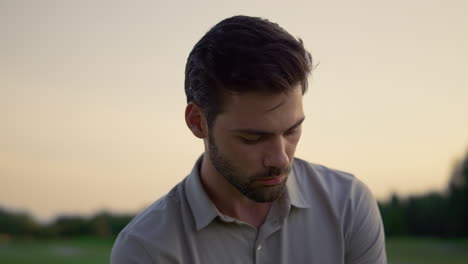 Hombre-Concentrado-Posando-Afuera.-Chico-Joven-Mirando-Alrededor-En-El-Campo-Del-Curso-Al-Atardecer.