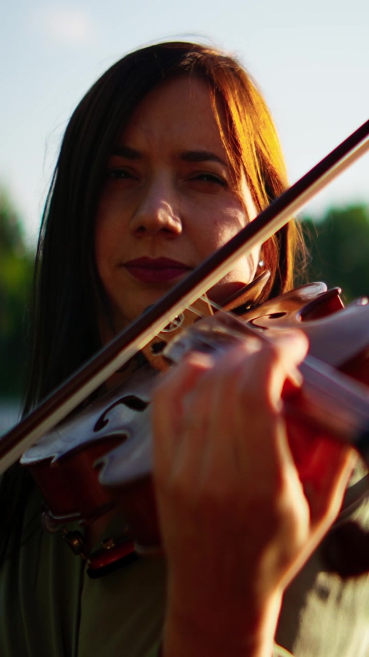 Young Woman Playing Violin Outdoors at Sunset