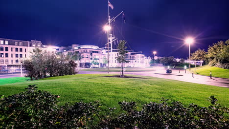 Hiperlapso-De-Varios-Vehículos-Que-Cruzan-La-Calle-En-Guernsey-Por-La-Noche-Con-La-Ciudad-Iluminada