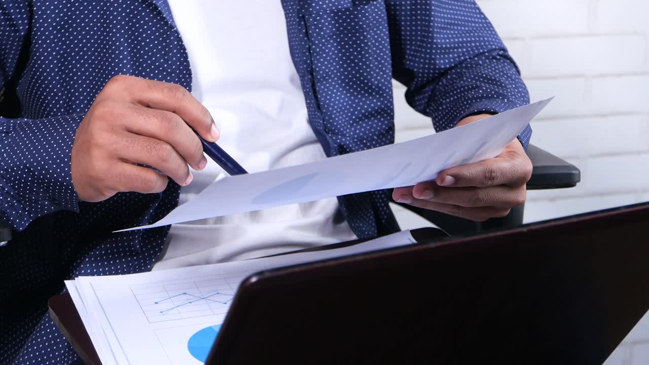 hombre de negocios revisando documentos y gráficos