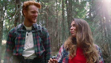 happy woman and man hiking in woods. travelers walking in fairytale forest