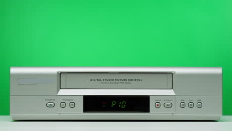 hand inserting vhs tape into a vintage vcr