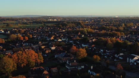 Britische-Nachbarschaftswohnungsluftaufnahme,-Die-über-Die-Herbstlich-Gefärbten-Dächer-Des-Frühen-Morgensonnenaufgangs-Hinabsteigt