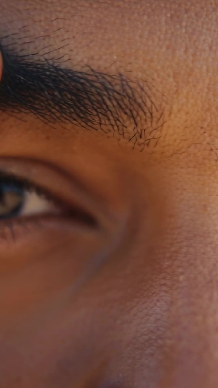 Vertical video: Panning cam showing man squinting, finger touching brow on deck from sun, eye glint