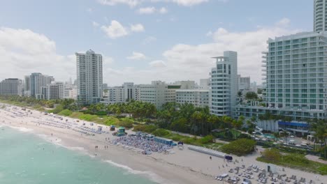 vista aérea de un complejo vacacional tropical. imágenes de diapositivas y panorámicas de una playa de arena bordeada de palmeras y hoteles. miami, ee.