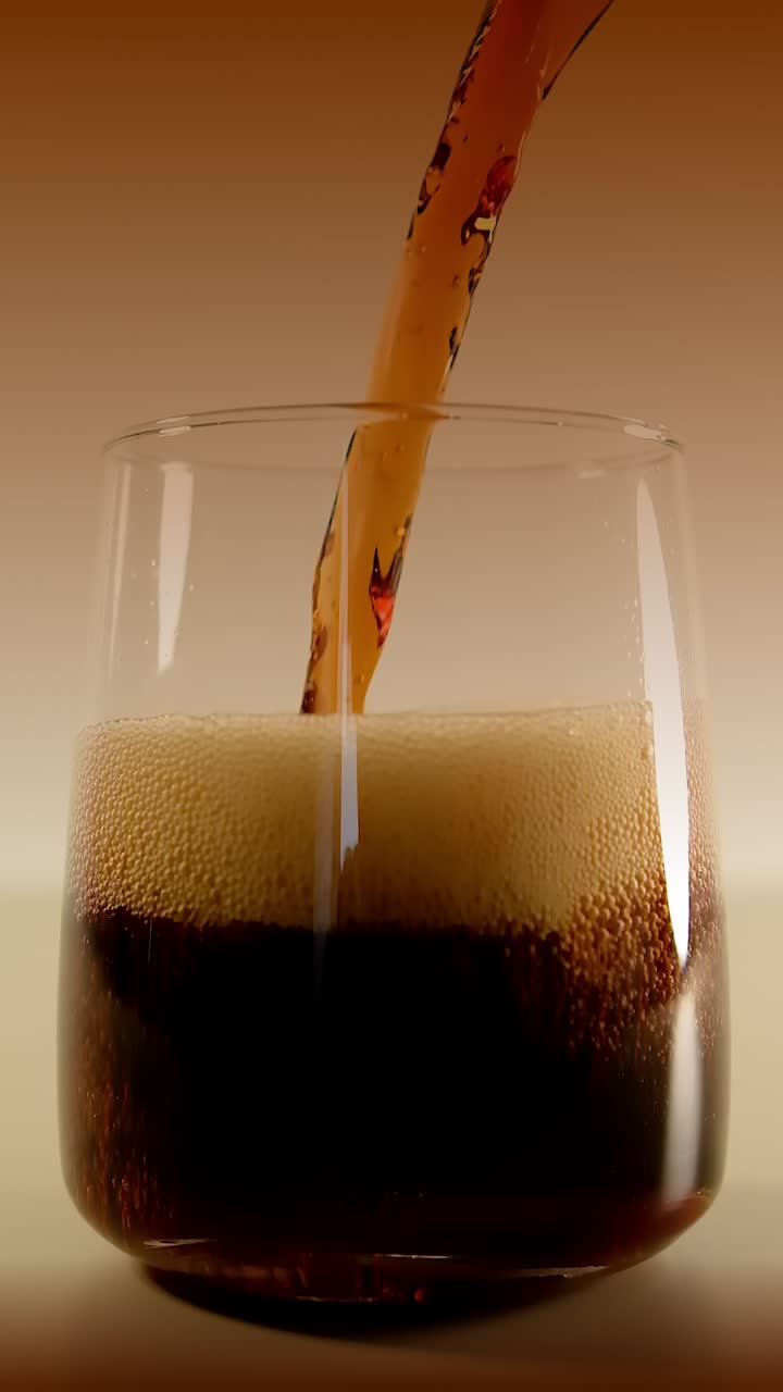 Deliziosa e gustosa bevanda gassata alla cola che si versa in un bicchiere al rallentatore.