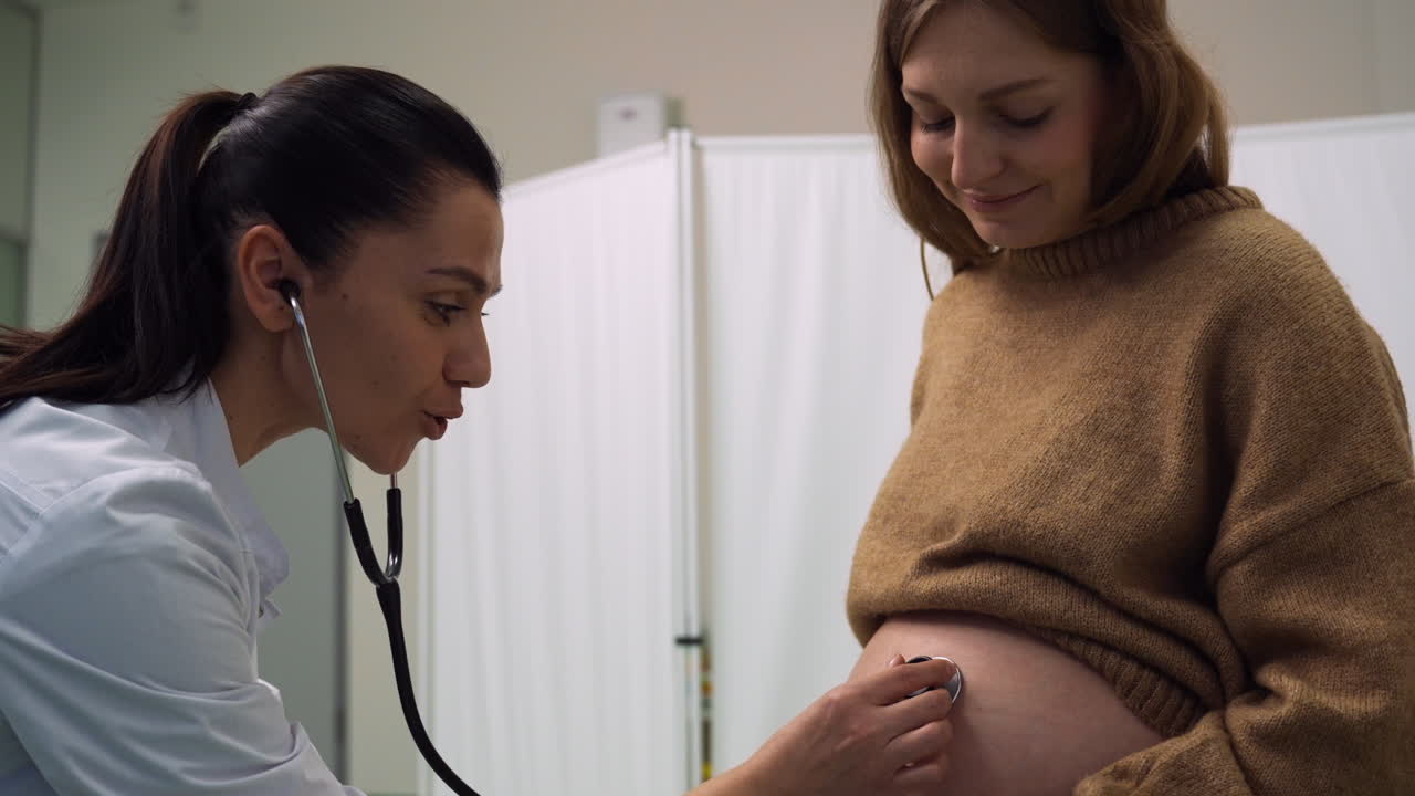 Doctor checking pregnant woman's belly