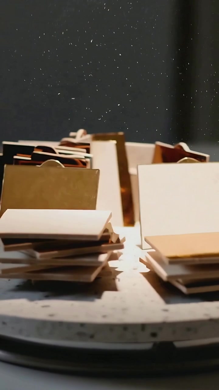 Vertical video: Panning camera showing tiles on speckled turntable with bags, tags