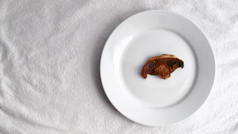 Dried-Porcini-mushroom-on-white-ceramic-tableware-on-white-table-mat