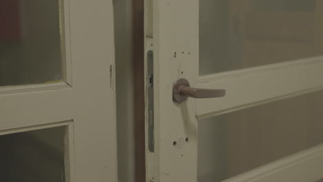 close-up of a white vintage door with metal handle, indoor setting