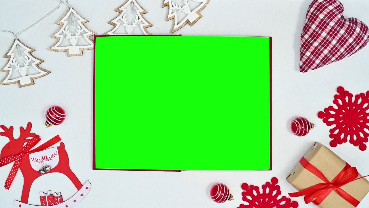 libro de pantalla verde con adornos de navidad y luces parpadeantes en tema blanco.