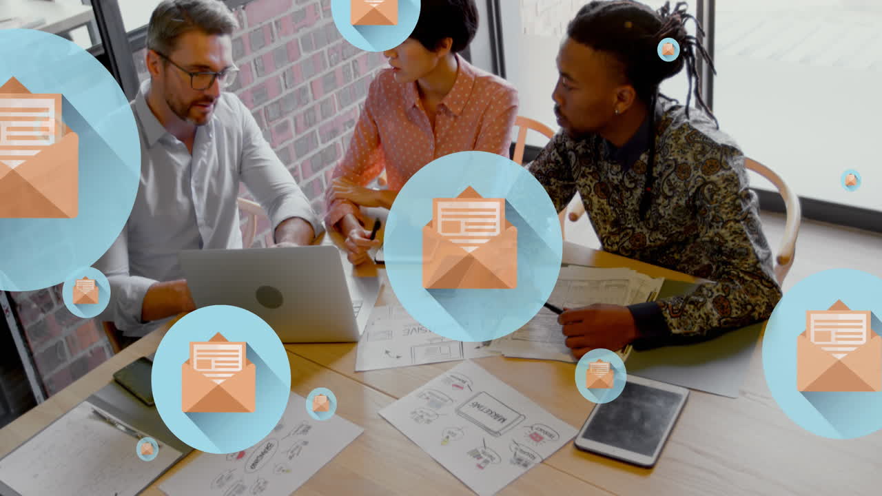 Animation of letter in open envelope icons over diverse coworkers discussing on desk in office
