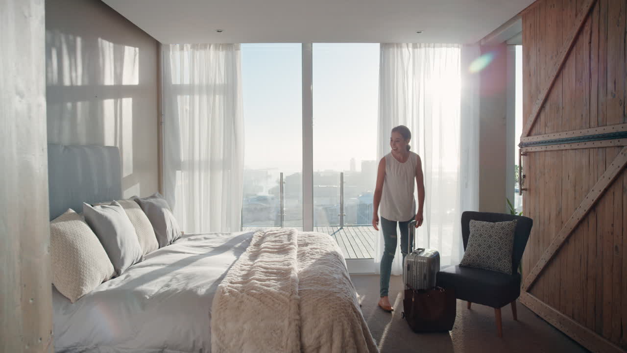mujer joven feliz saltando en la cama descansando después de un viaje exitoso disfrutando de la libertad de estilo de vida independiente en la habitación del hotel