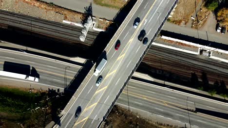 aerial overhead orbit zoom in hyperlapse shot of cars driving on highway 1 and an underpass intersection road and train tracks in kamloops, thompson okanagan in a desert environment