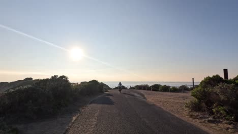 ciclista montando a través de un sendero costero pintoresco