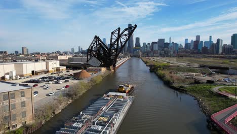 Tug-Boat-And-Barge-On-River-With-Downtown-City-Skyline