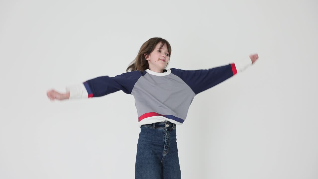 Energetic young girl jumping and dancing in a studio