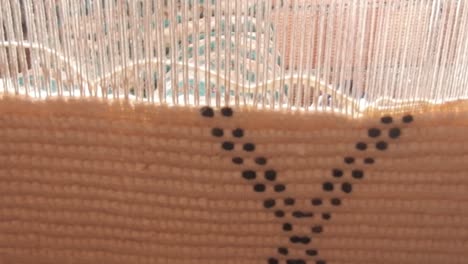 close up on a moroccan girl weaving a carpet with a manual waving machine, carpet weaving , needlework , morocco