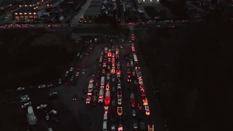 Drohnen-4K-Aufnahmen,-Weihnachtsparade,-Polizeisirene-Signalisiert-Nachts-Vorwärtsfliegenden-Verkehr-Und-Zeigt-Die-Stadt-In-Der-Ferne