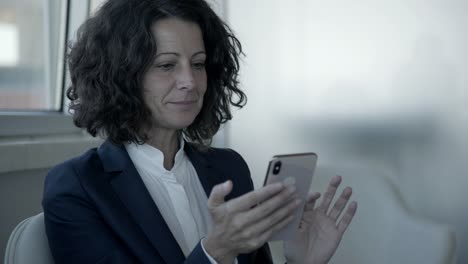 mujer de negocios sonriente usando un teléfono inteligente