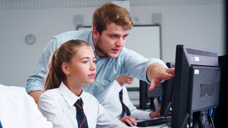 Teenage Students Wearing Uniform Studying In IT Class