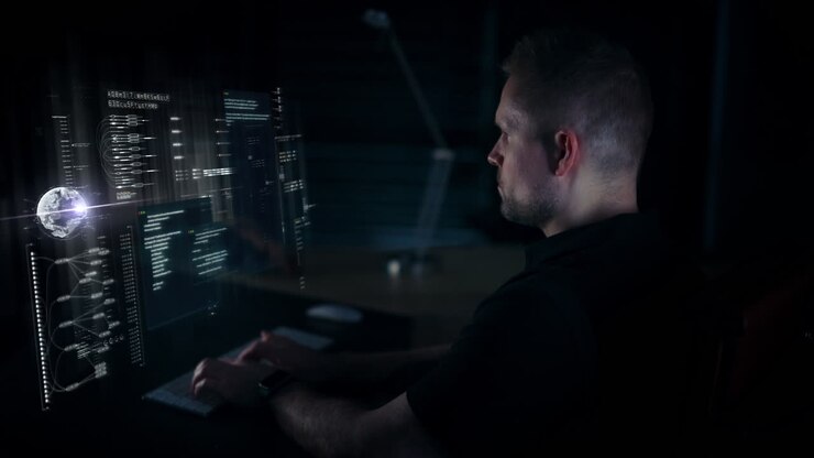 Adult male typing data on keyboard reflected in a hologram