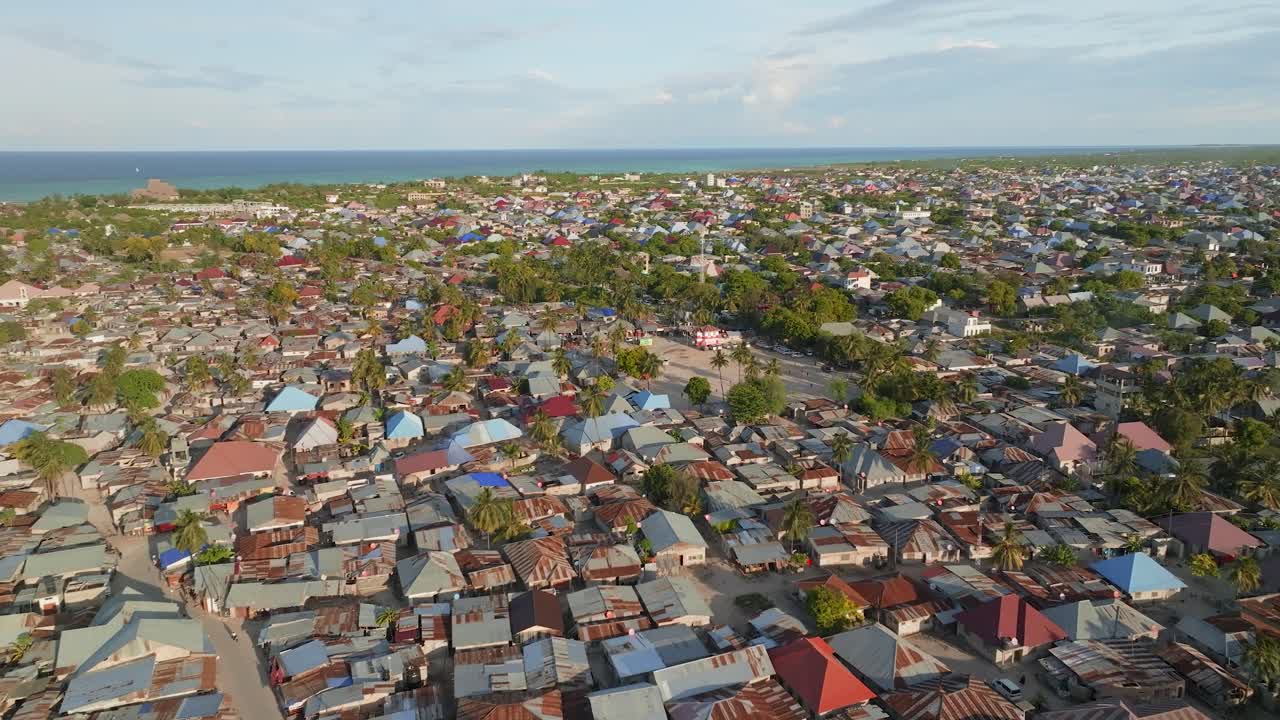 Penerbangan drone sinematik di ketinggian tinggi di atas desa Nungwi di Zanzibar. Atap tepi pantai, lanskap tropis, dan kehidupan pulau menciptakan suasana udara yang damai dan imersif, ideal untuk perjalanan dan budaya.