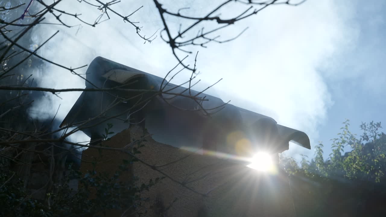 컨트리 하우스 굴뚝 백라이트 밝은 태양 플레어에서 흐린 연기