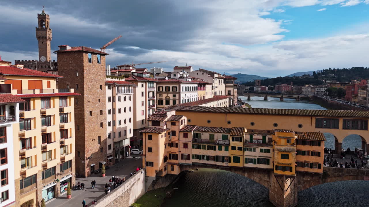 Storico Ponte Vecchio a Firenze, Italia, con edifici e negozi colorati.