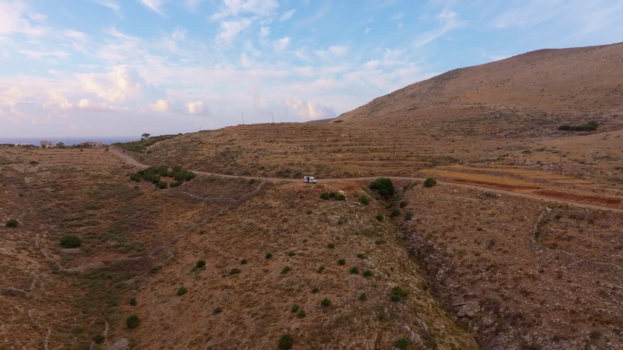Le prime luci dell'alba avvolgono un camper e colline aspre in tonalità calde, Lagia, Grecia