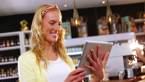 mujer sonriente usando una tableta digital