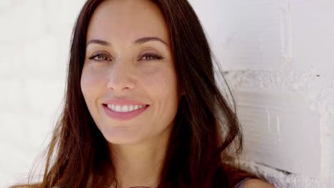 un primer plano de una mujer con el cabello marrón sonriendo