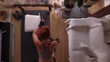 Overhead-shot-of-a-woman-exercising-ttriceps-and-back-with-dumbbells