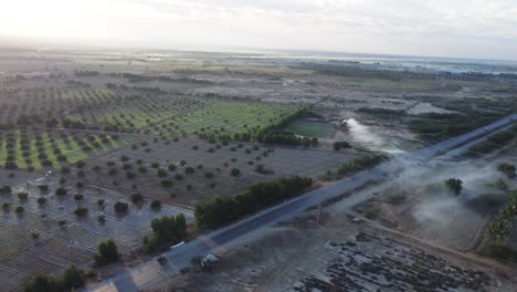 aerial view of cars and bikers on a highway in the middle of farm field landscape in balochistan