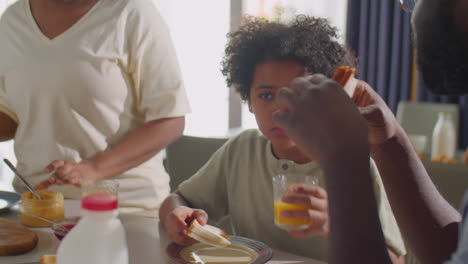 african american family eating breakfast and talking