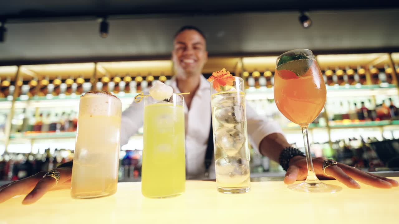 Bartender Presenting a Variety of Colorful Cocktails on a Bar