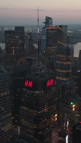 vertical drone shot of high-rise of times square and hudson yards, dusk in ny